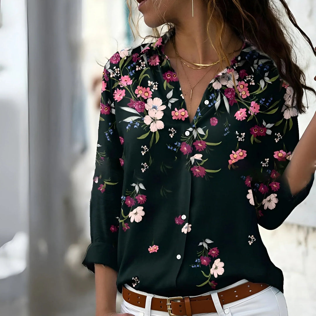 Kvinna i mönstrad mörk blus med blommor