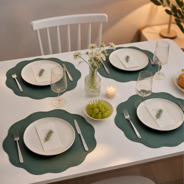 Dukat matbord för fyra personer med gröna Wearbella bordsunderlägg och blomvas