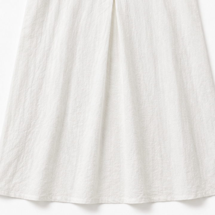 Detaljbild på volanger och knappar på damklänning i feminin stil