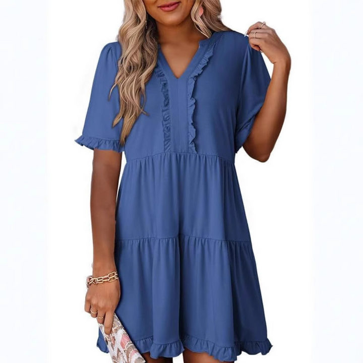 Kvinna i blå avslappnad V-ringad miniklänning visad framifrån