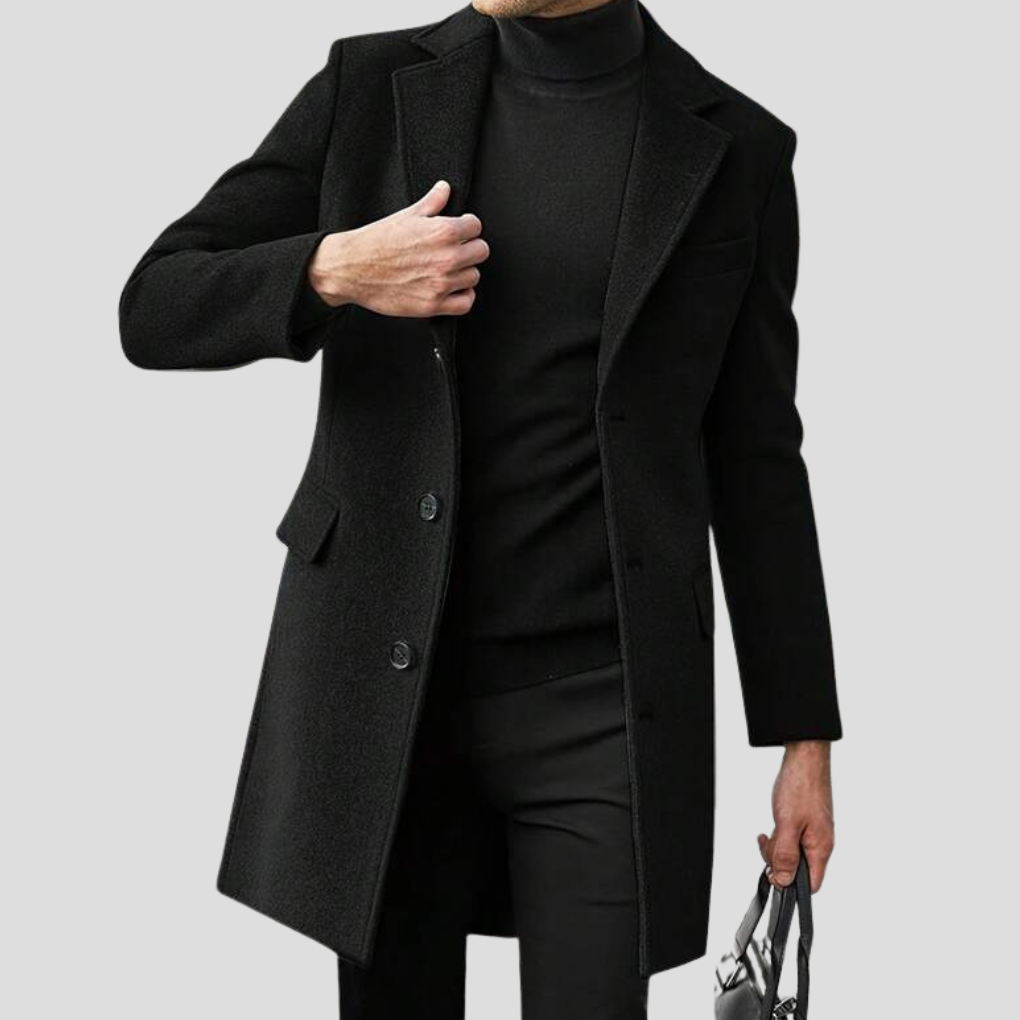 Man bär en elegant svart revere-överrock i klassisk modell