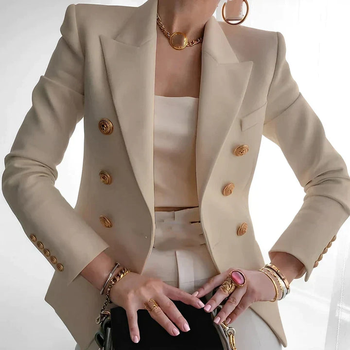 Elegant beige damkavaj med guldknappar och accessoarer