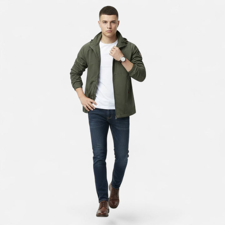 Man som bär den armégröna utomhusjackan tillsammans med jeans