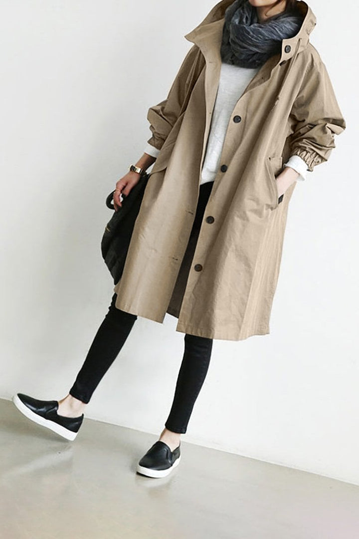 Mörk damjacka i trenchcoat-modell visad bakifrån med praktisk huva