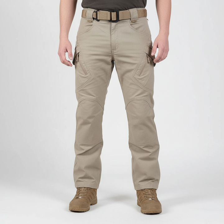 Helkroppsbild på man i khaki cargobyxa framifrån mot vit bakgrund