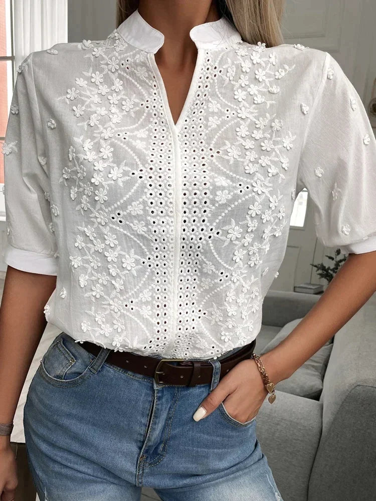 Vit blus med mandarinkrage och blomdetaljer