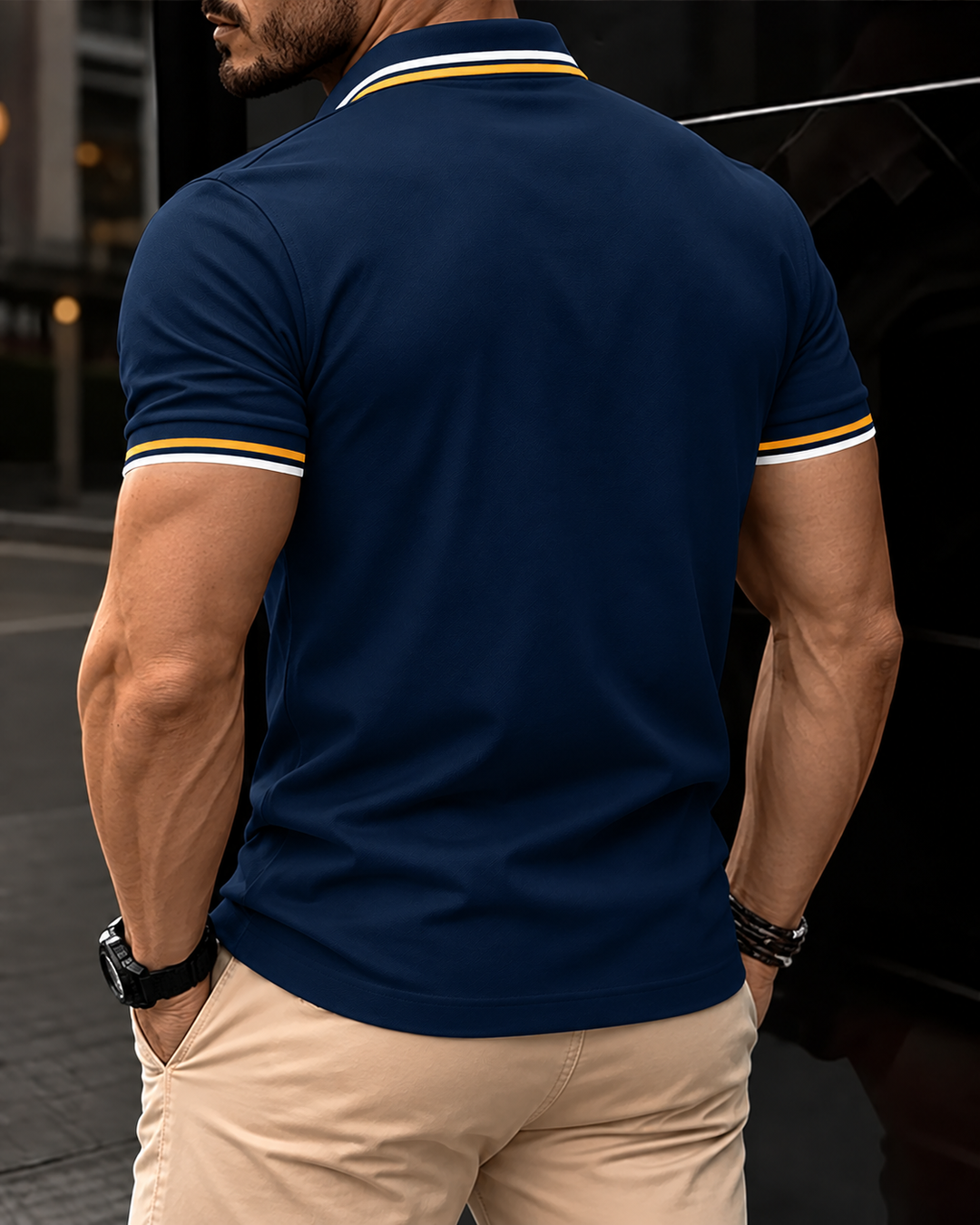 Man bär marinblå kortärmad polo bakifrån
