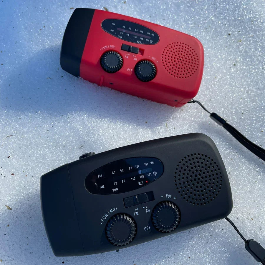 Nödradio med solceller och handvev placerad på ett träbord för krisberedskap