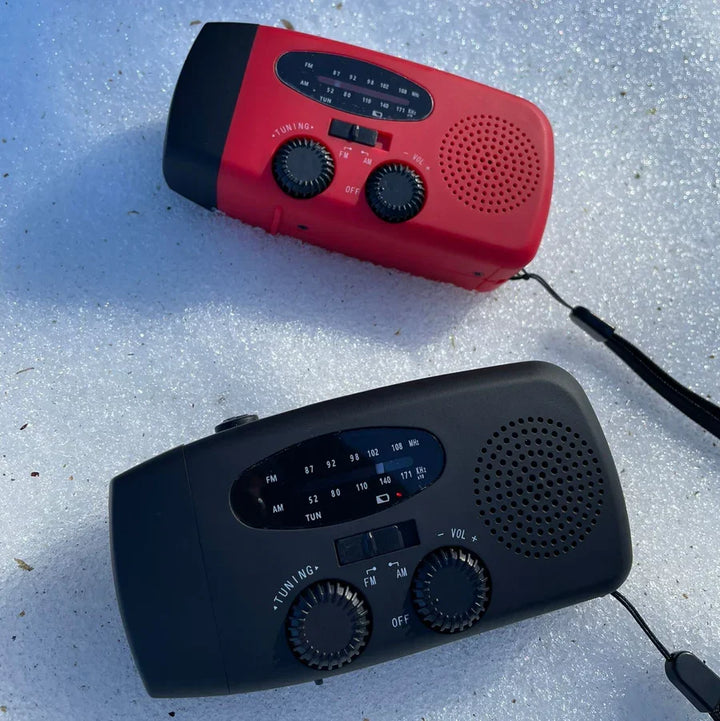 Nödradio med solceller och handvev placerad på ett träbord för krisberedskap