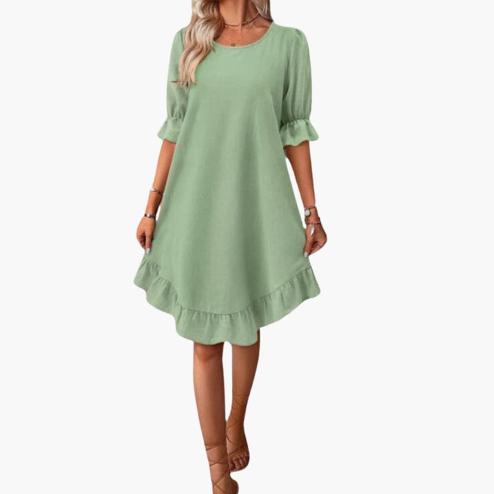 Elegant sommarklänning för dam med korta volangärmar och feminin silhuett.