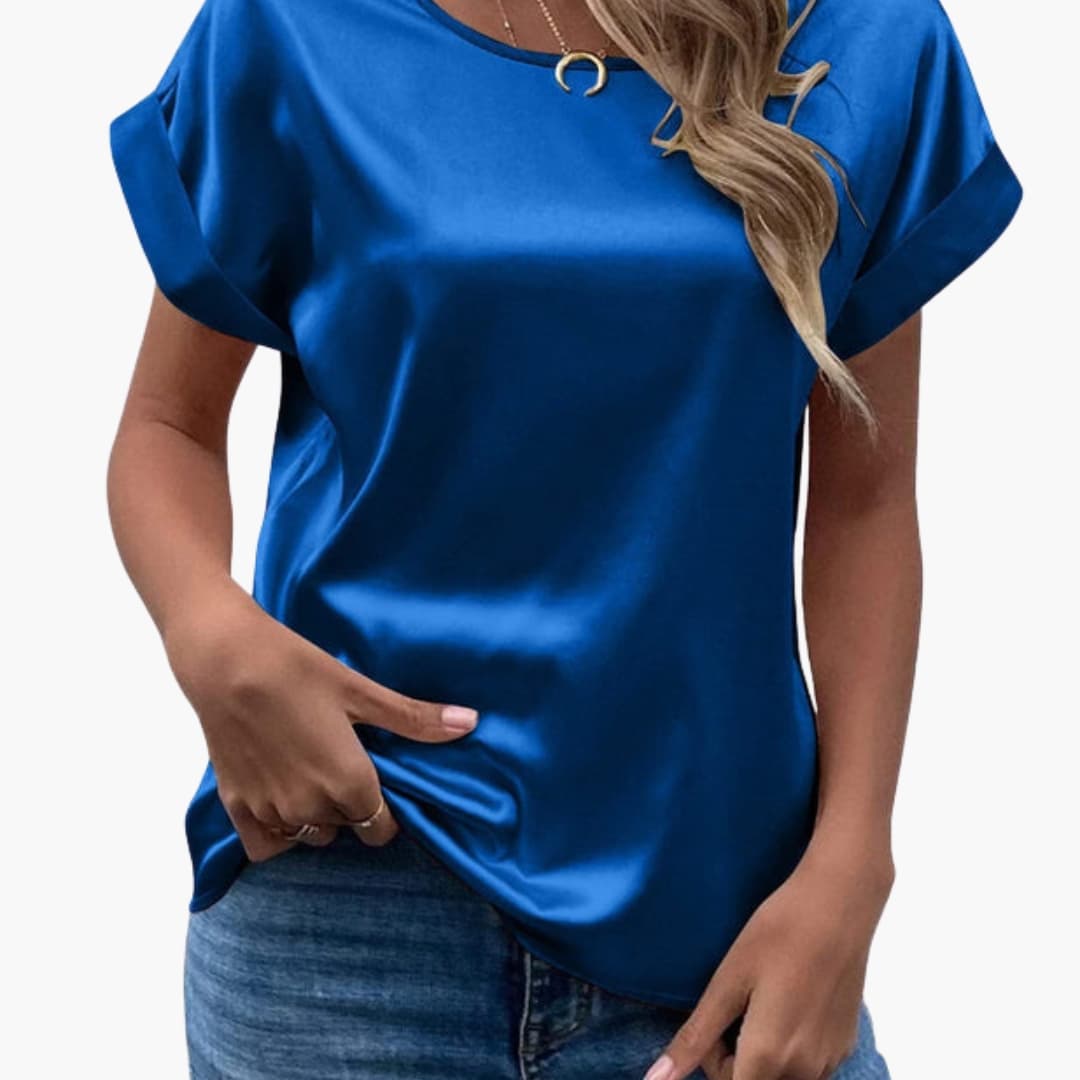 Kvinna i kungsblå satinlook-blus med kort ärm och rund hals
