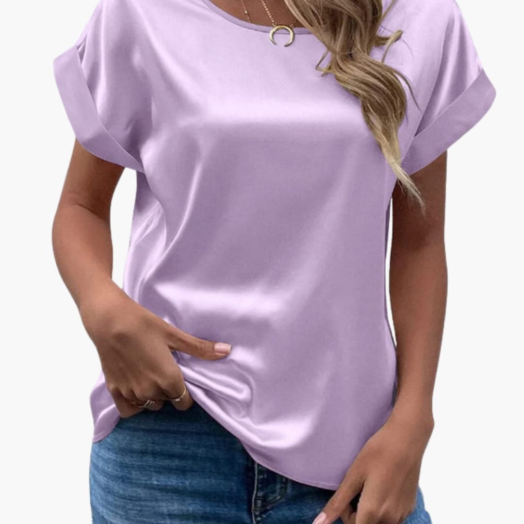 Kvinna i ljuslila satinlook-blus med kortärmad design