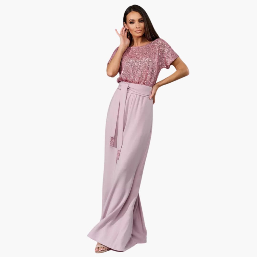 Kvinna i rosa paljettjumpsuit med midjebälte