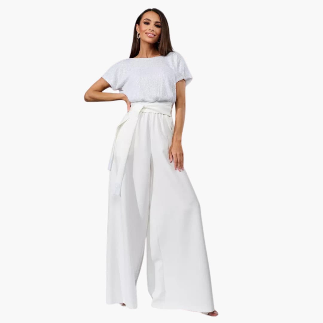Kvinna i vit paljettjumpsuit med elegant design