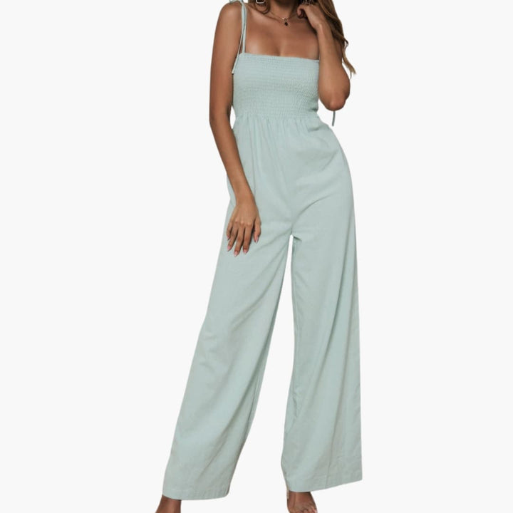Modell i grön jumpsuit med formad överdel och vida ben framifrån