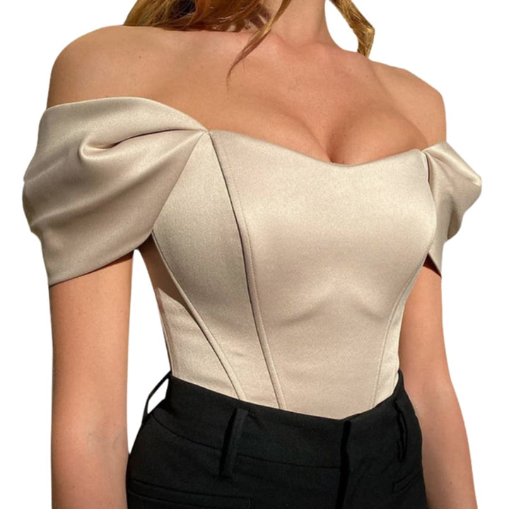 Kvinna i elegant gräddvit off-shoulder-topp med långa ärmar