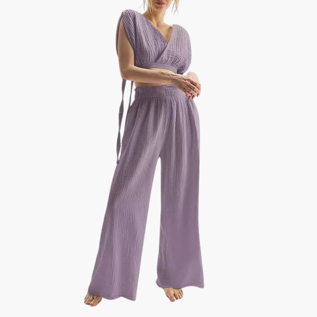 Kvinna som bär lila tvådelad jumpsuit med vida ben och V-ringning