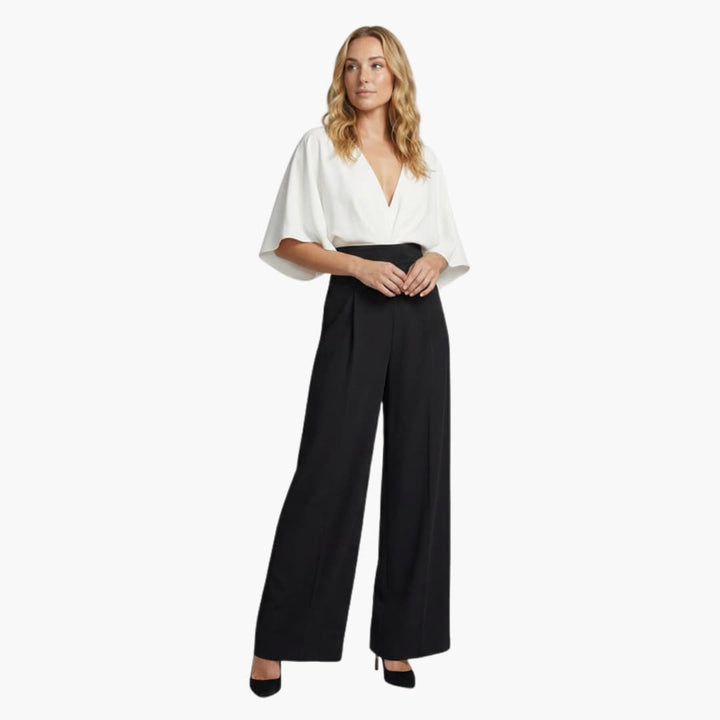 Kvinna som bär en elegant vit och svart byxdress med vida ben