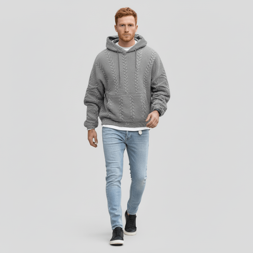 Helkroppsbild på man som bär grå stickad huvtröja och ljusa jeans