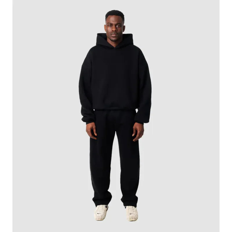 Svart träningsset för herrar visat på modell med matchande hoodie och byxor