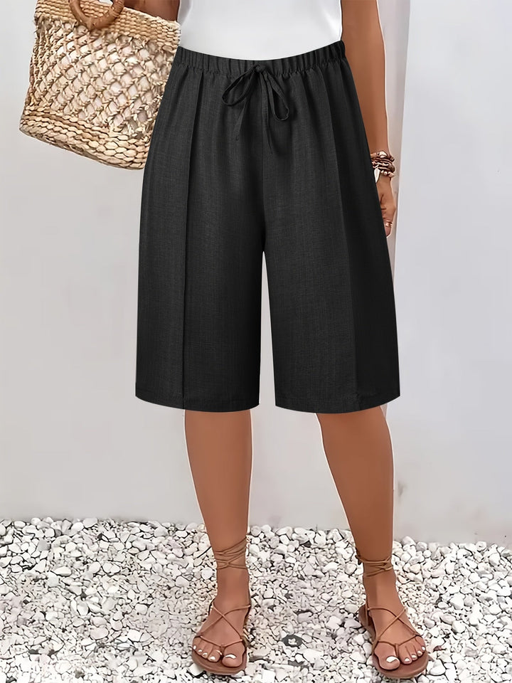 Kvinna i svarta eleganta shorts med elastisk midja och dragsko