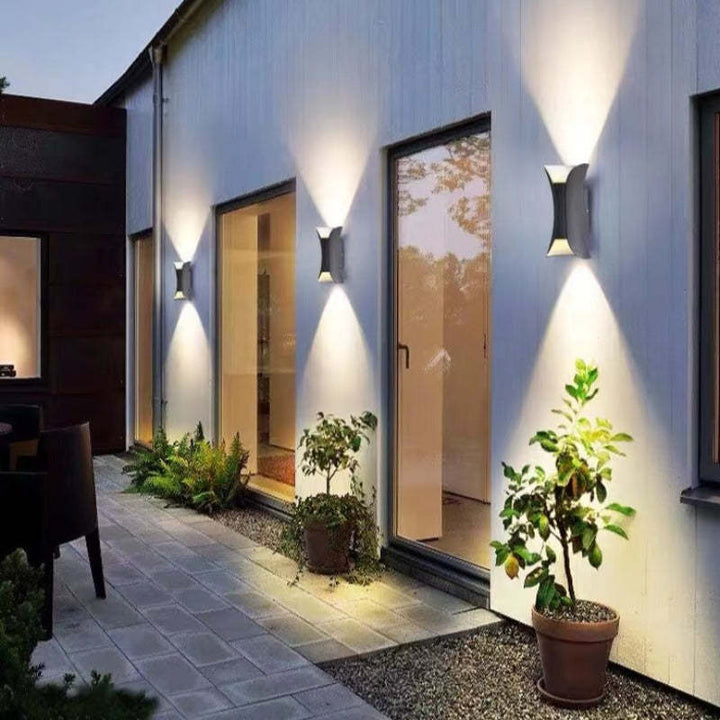 Arcora Curve LED väggarmaturer upplysta på modern husfasad