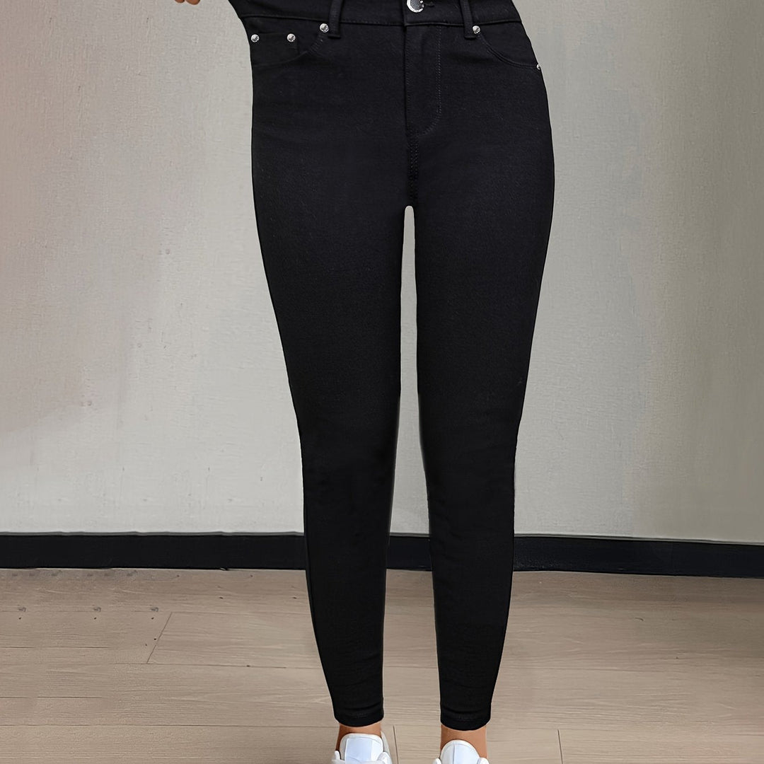 Framifrån av dam i svarta högmidjade skinny jeans med sneakers