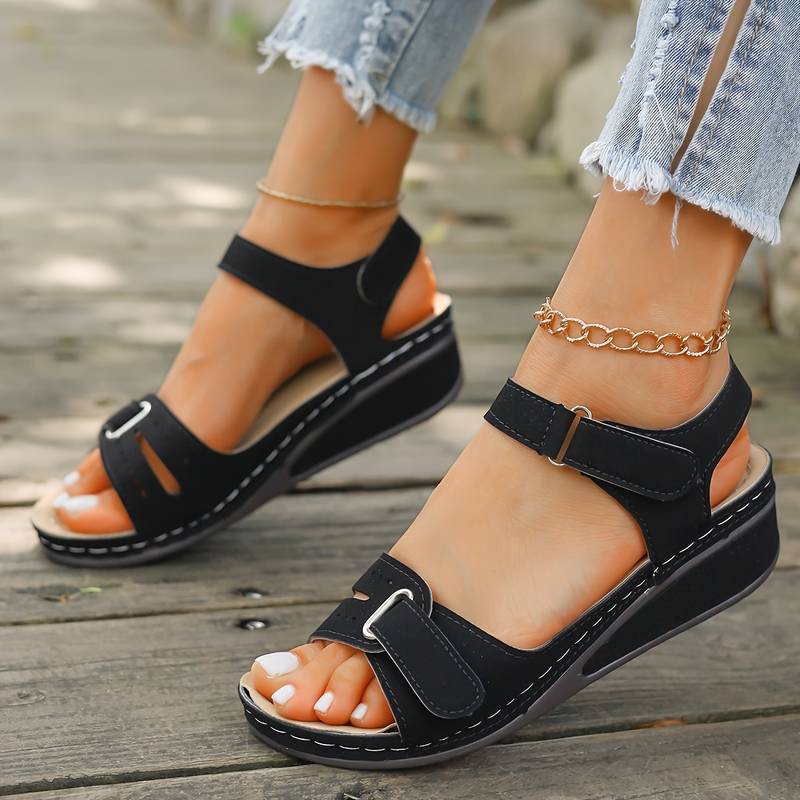 Stilren kilklackssandal Alena för dam. Slip-on med ergonomiskt fotvalvsstöd, perfekt för sommaren.