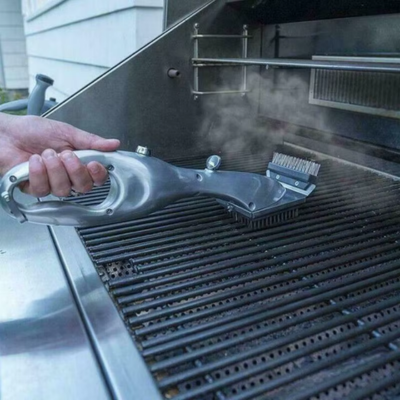 Närbild på ångrengöringsborste i rostfritt stål som används på grillgaller