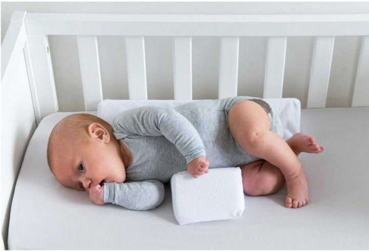 Ergonomisk antirullande babykudde som håller spädbarn säkert på sidan. Justerbar design i minnesskum.