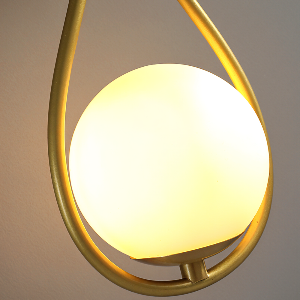 ArtLoop vägglampa i mässing med stilren droppdesign. Elegant accent för vardagsrummet.