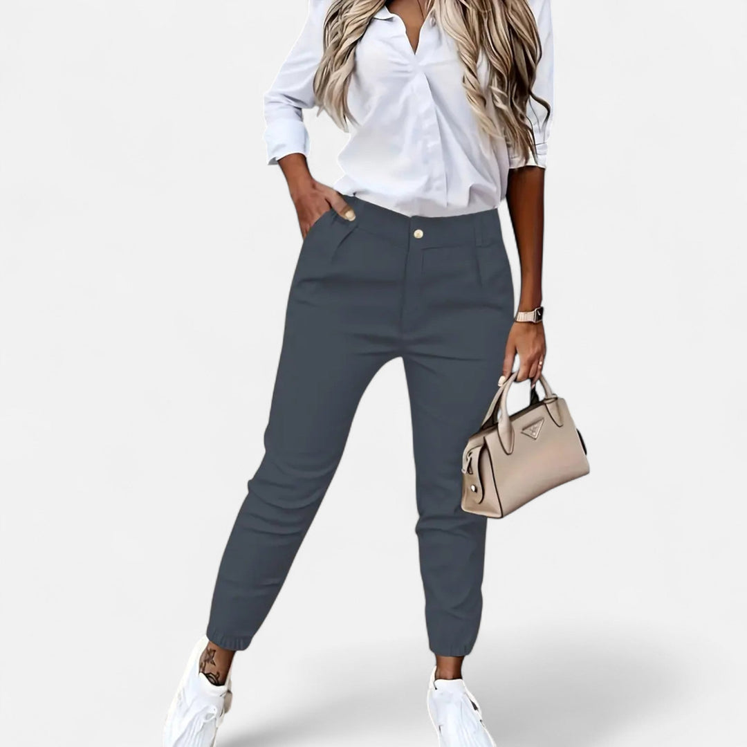 Närbild på tyg och sömmar i svarta högmidjade slim-fit byxor för dam