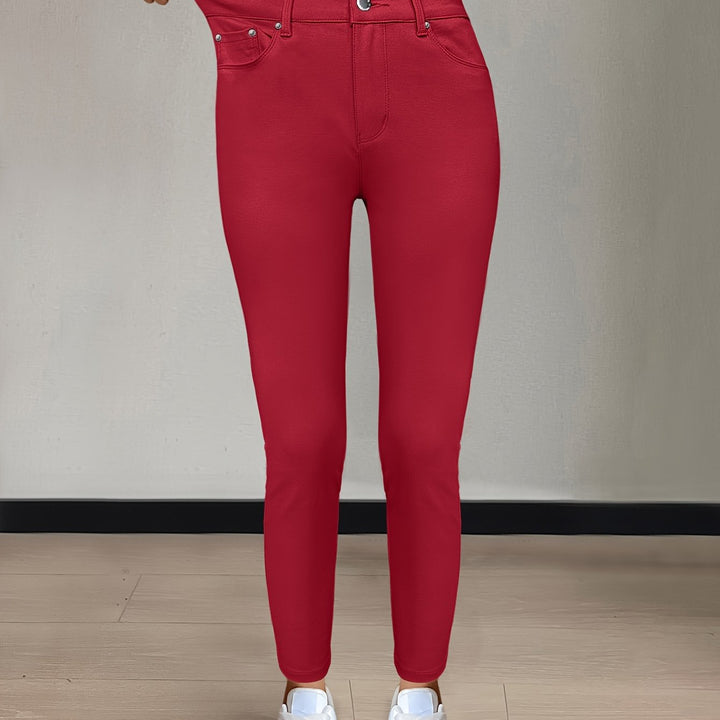 Närbild på knapp och gylf på mörkblå skinny damjeans