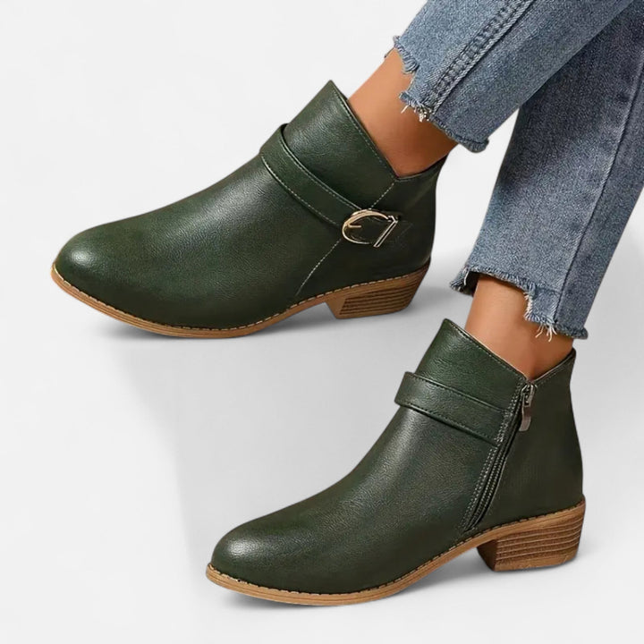 Elegant damstövlett i ankellängd med snygg spetsig tå och dekorativt spänne för en chic look.
