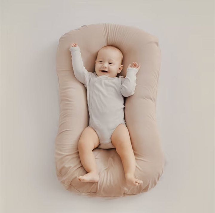 Ergonomisk sovstödskudde för baby placerad på en neutral bakgrund