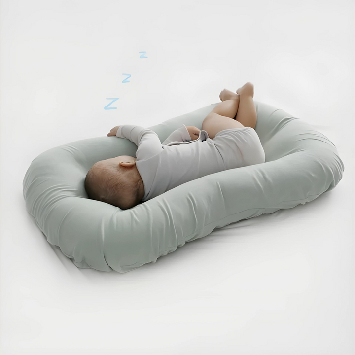 Grön babykudde med sovande spädbarn och Z-symboler