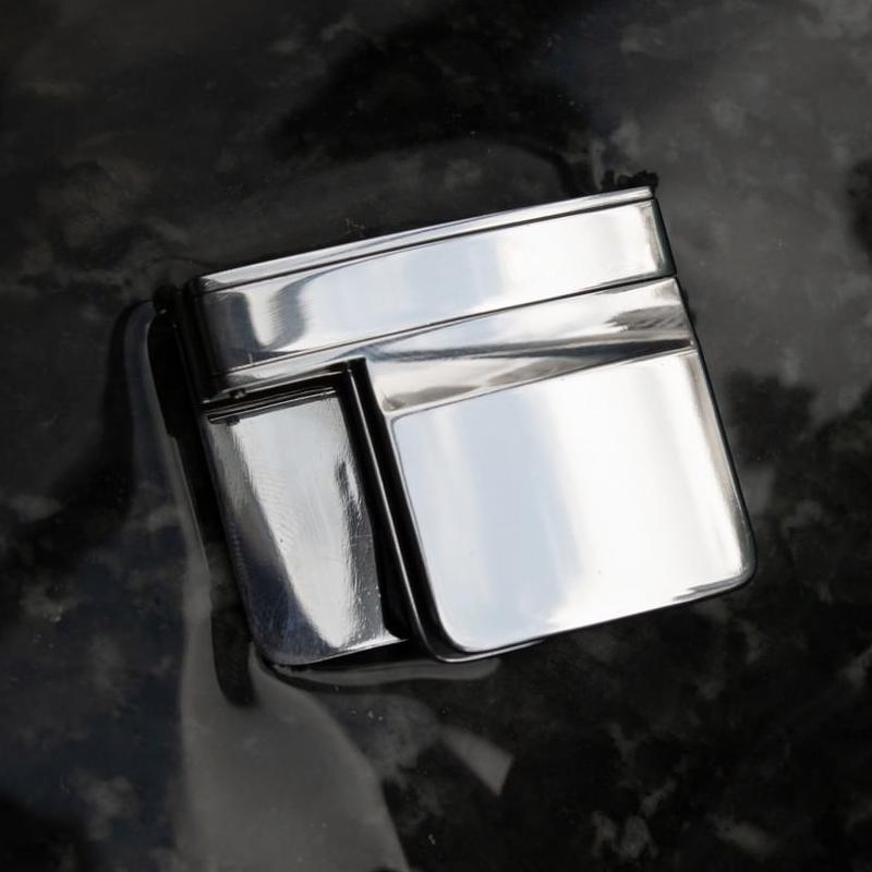 "Bältesjusteringsklämma i silver, kompakt och diskret design, ger perfekt passform för byxor och kjolar, elegant accessoar."