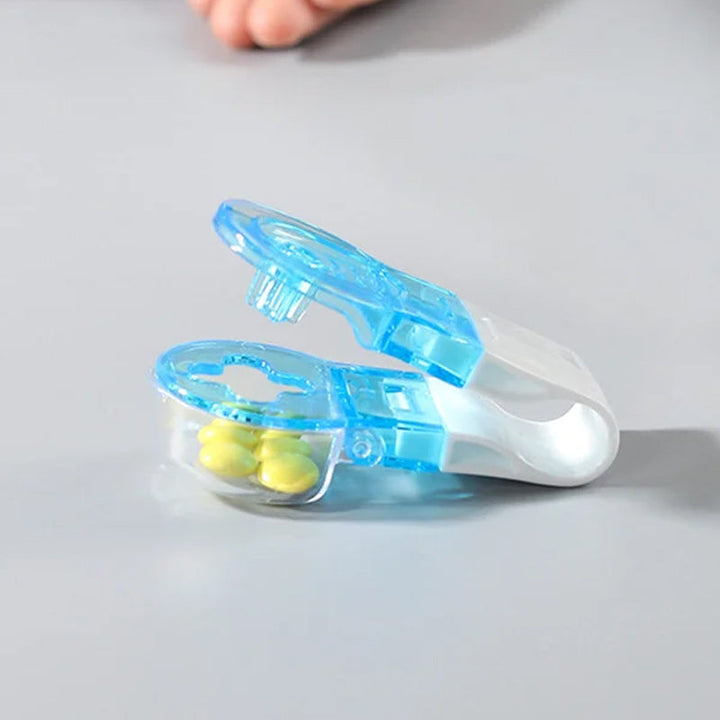 Bärbar pillerborttagare i vit och blå design med praktisk förvaringsbox för enkel pillerhantering hemma och på resa.