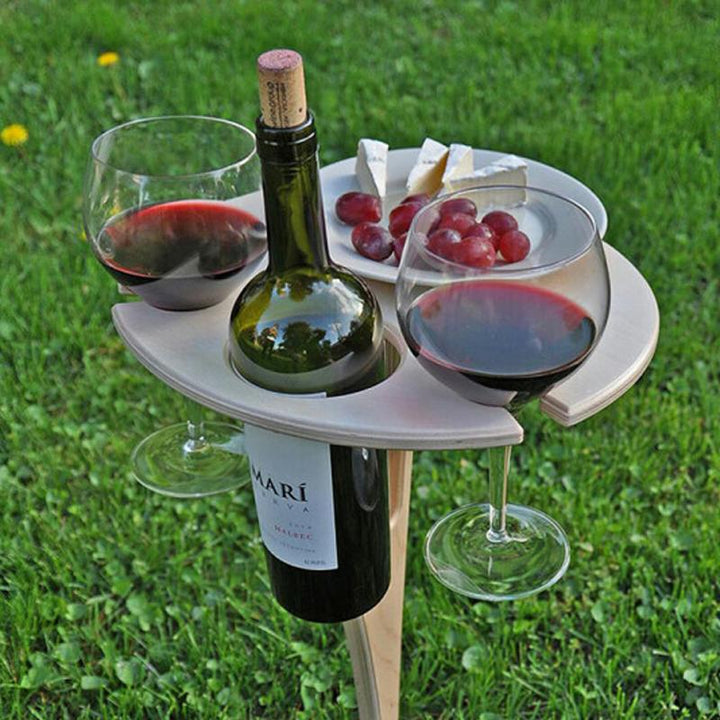 "Bärbart vinbord i björk, fällbar design, för utomhusbruk med plats för vinflaska, glas och snacks, perfekt för picknick."