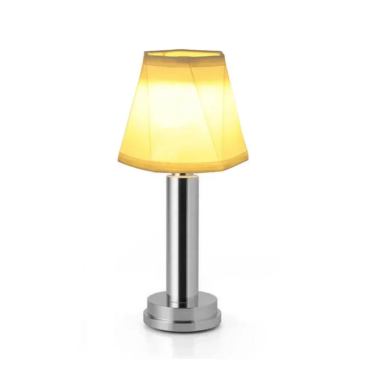 Uppladdningsbar bordslampa med varmt LED-ljus placerad på ett modernt sidobord