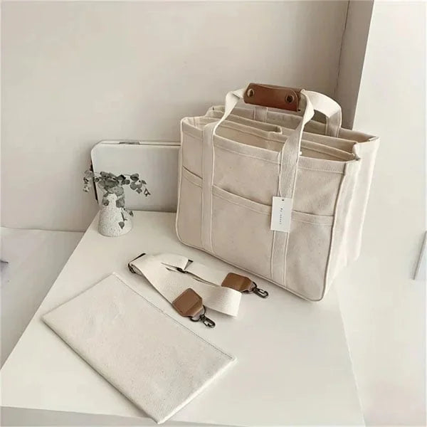 Person bär en rymlig beige bärkasse fylld med varor. Perfekt shoppingväska för en stilfull vardag.