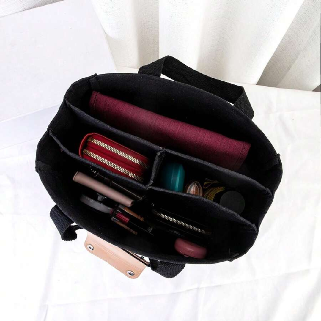 Detaljbild av en praktisk och rymlig svart bärkasse, en elegant unisex vardagsväska för alla tillfällen.