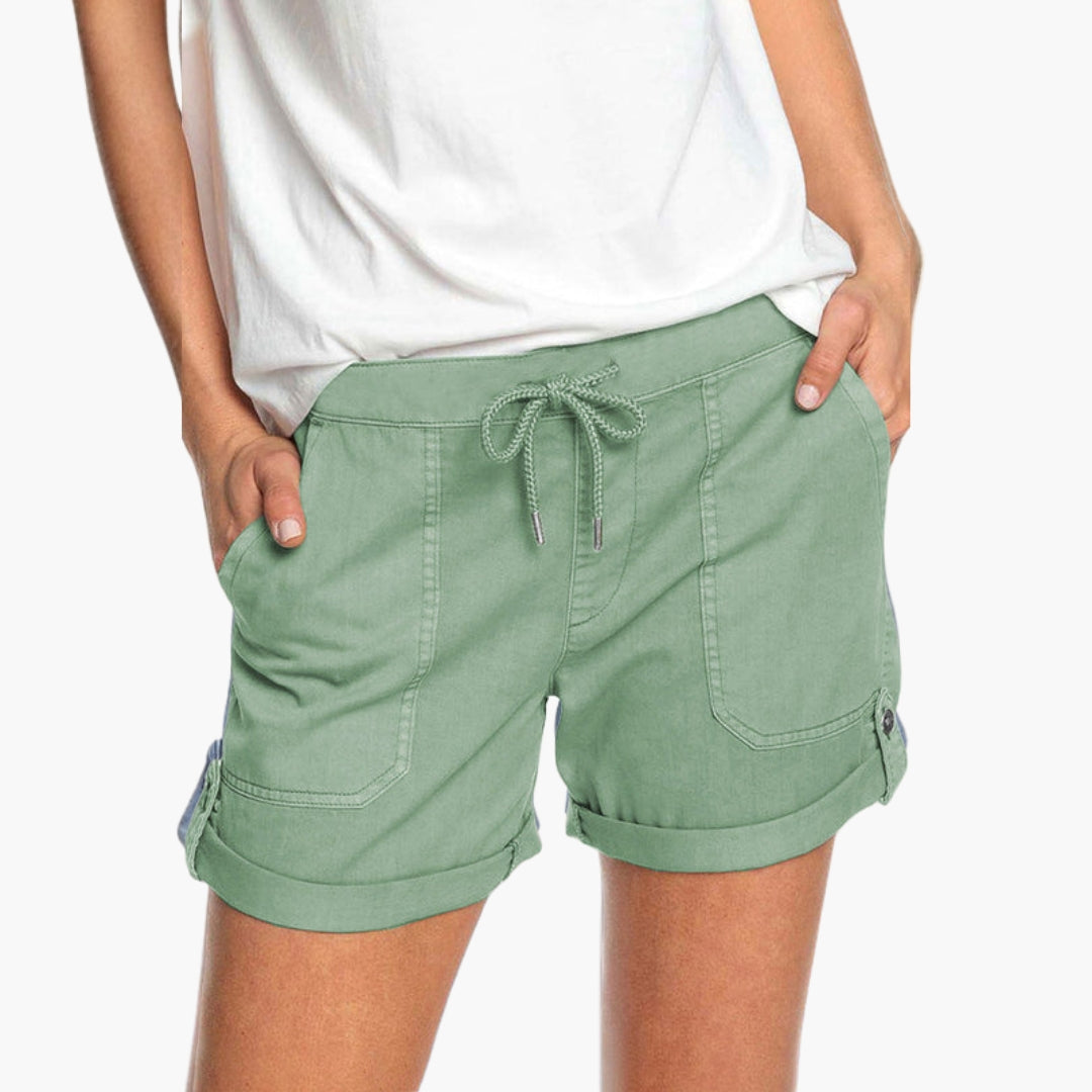 Nära bild av damshorts tyg, visar kvaliteten på det bekväma materialet med stretch och detaljer.