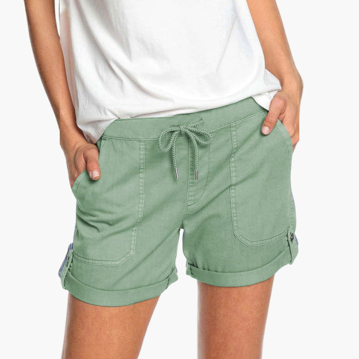 Nära bild av damshorts tyg, visar kvaliteten på det bekväma materialet med stretch och detaljer.