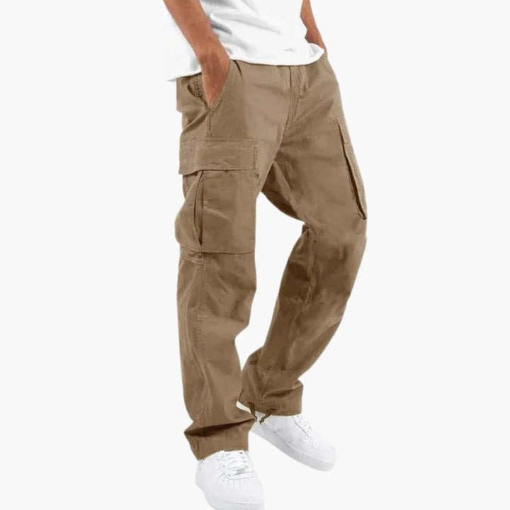 Bekväma herrcargobyxor sedda från sidan, visar den avslappnade passformen och de funktionella fickorna. Streetwear-stil.