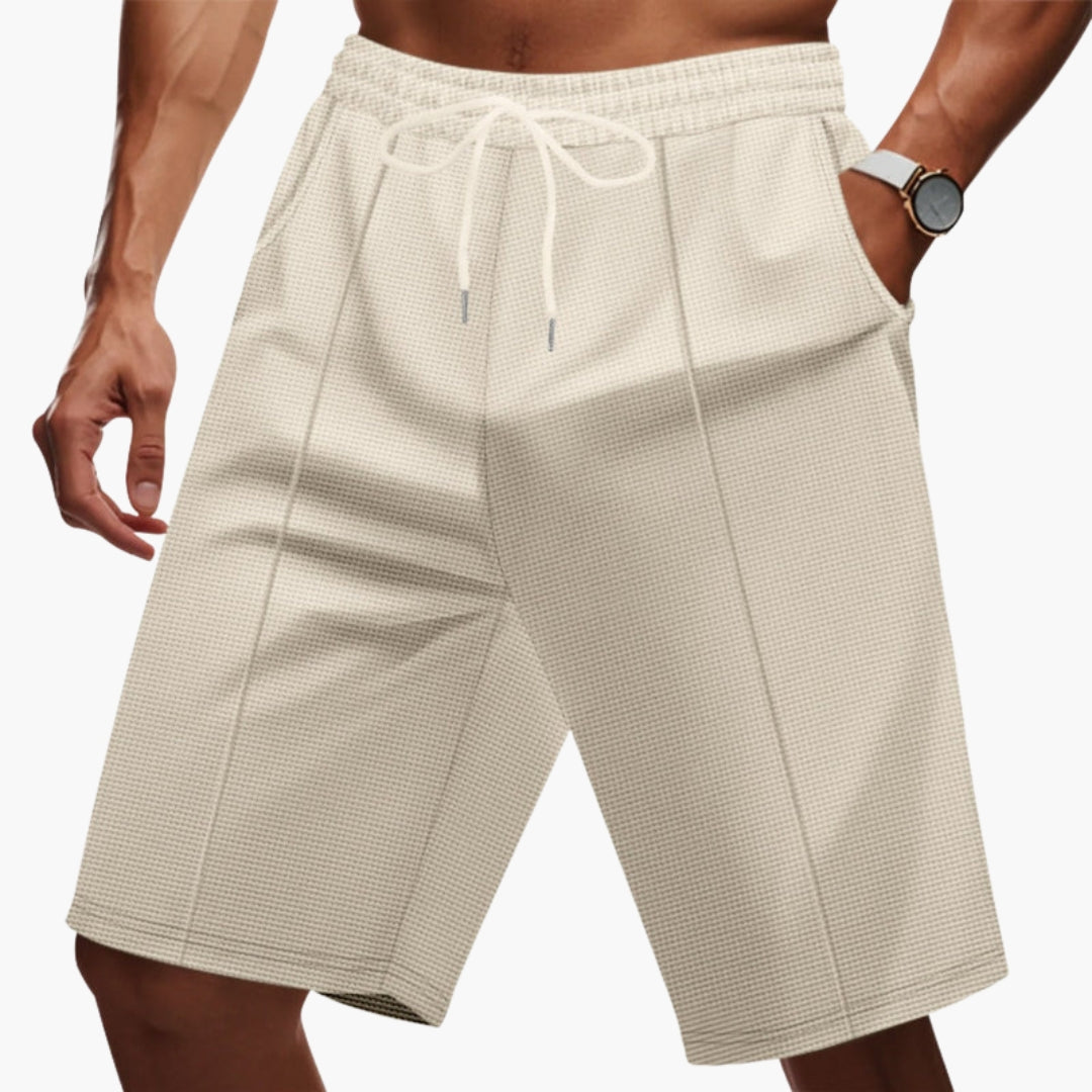 Kaki herrshorts med dragsko, elastisk midja och praktiska fickor för vardagskomfort.