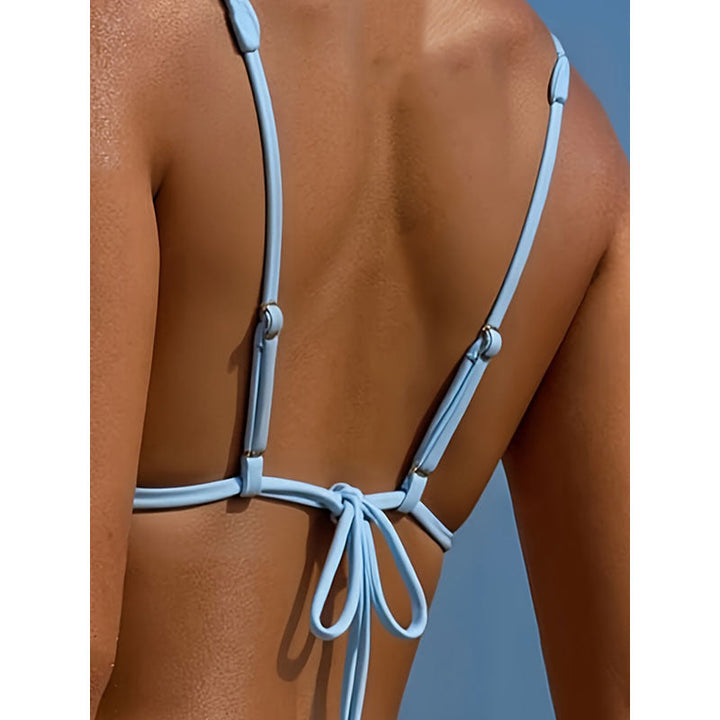 Kvinnors blå triangelbikini med hjärtformade detaljer och justerbara band. Snyggt strandmode.