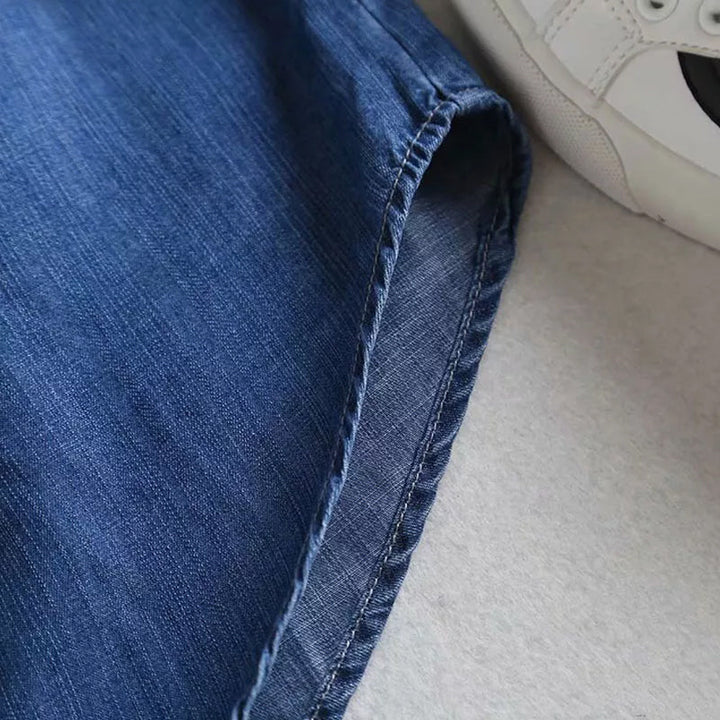 Baksida av blå dam denimskjorta, visning av ryggdetaljer och längd.