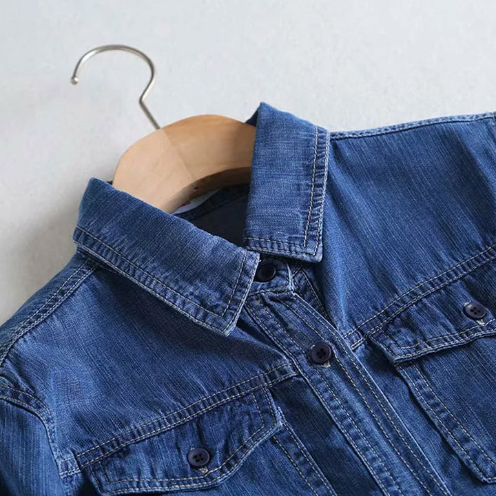 En modell som bär den blå dam denimskjortan, visar hur den faller.
