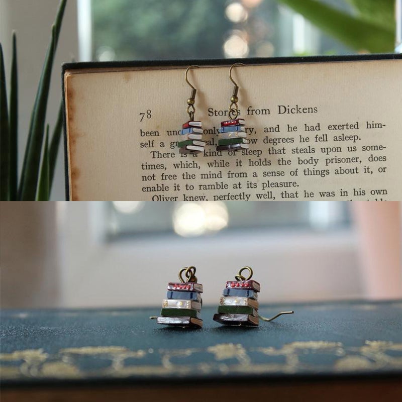 Örhängen med bokmotiv, handmålade damaccessoarer, design med liten bokhög, unikt stilfullt smycke för litteraturentusiaster.